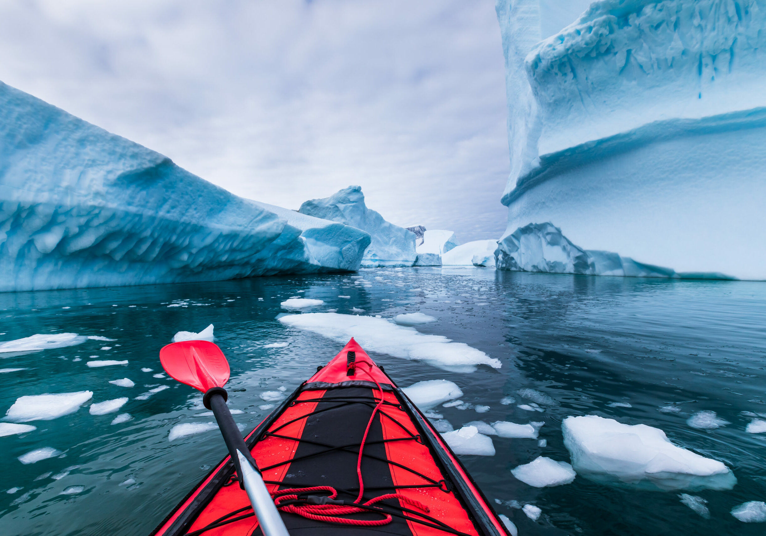 Kayaking in Antarctica between icebergs with inflatable kayak, extreme adventure in Antarctic Peninsula , beautiful pristine landscape, sea water paddling activity